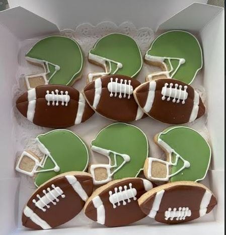 Football themed cookies with helmets and footballs in gift box