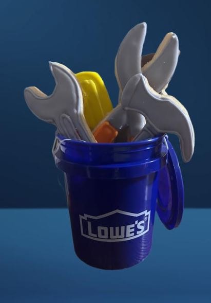Tool-shaped cookies displayed in a Lowe's branded blue bucket