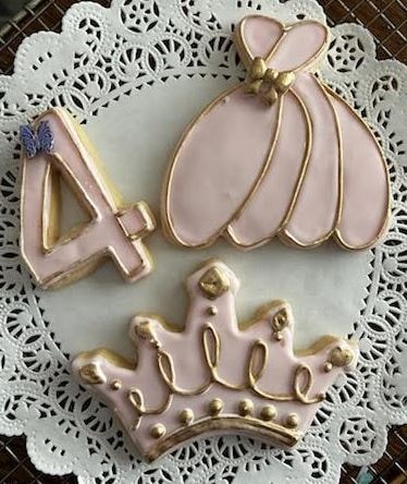Pink and gold princess cookies — number 4, ballgown dress, and crown on lace doily