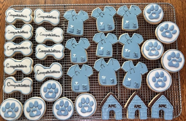Veterinary themed cookies with scrubs, paw prints, bones, and AMC doghouse designs