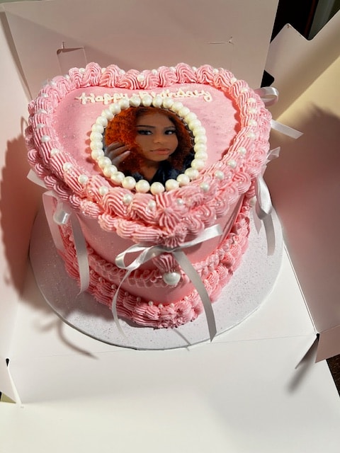 Pink heart-shaped birthday cake with photo portrait insert and pearls