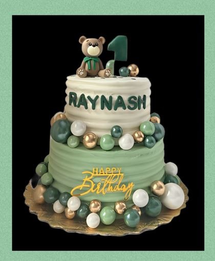 Green teddy bear birthday cake with bow and candles