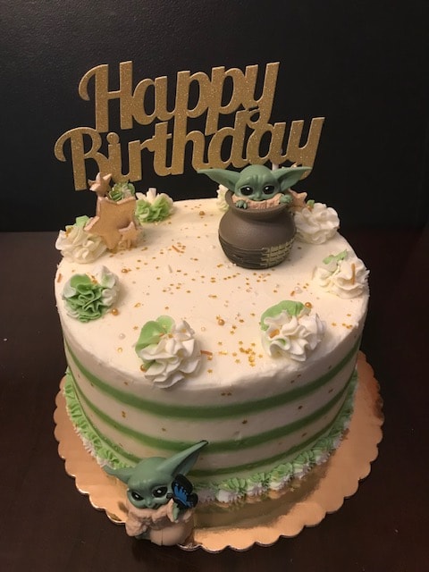 Baby Yoda Star Wars birthday cake with green and white frosting and Happy Birthday topper