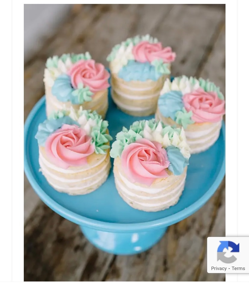 Mini naked cakes with pink and blue rosette frosting on blue cake stand
