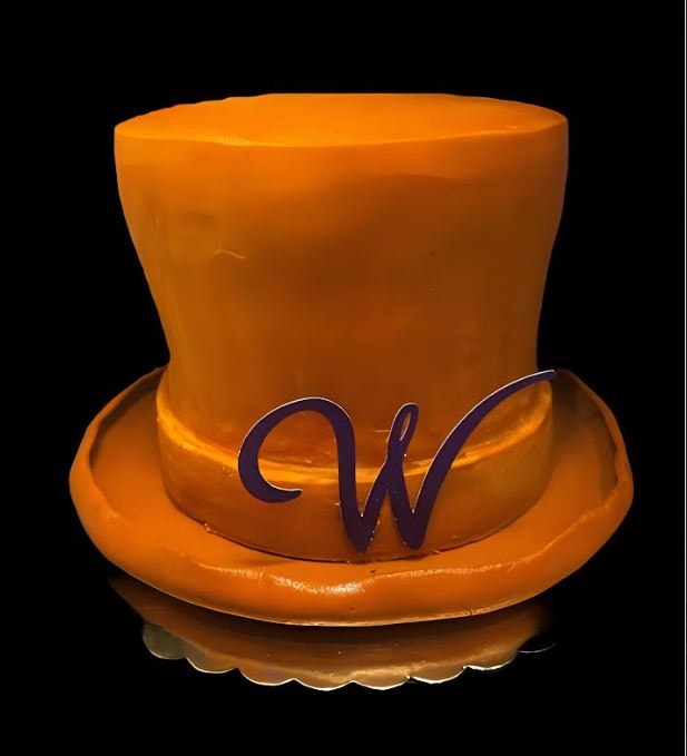 Willy Wonka top hat shaped cake in orange fondant with purple W monogram