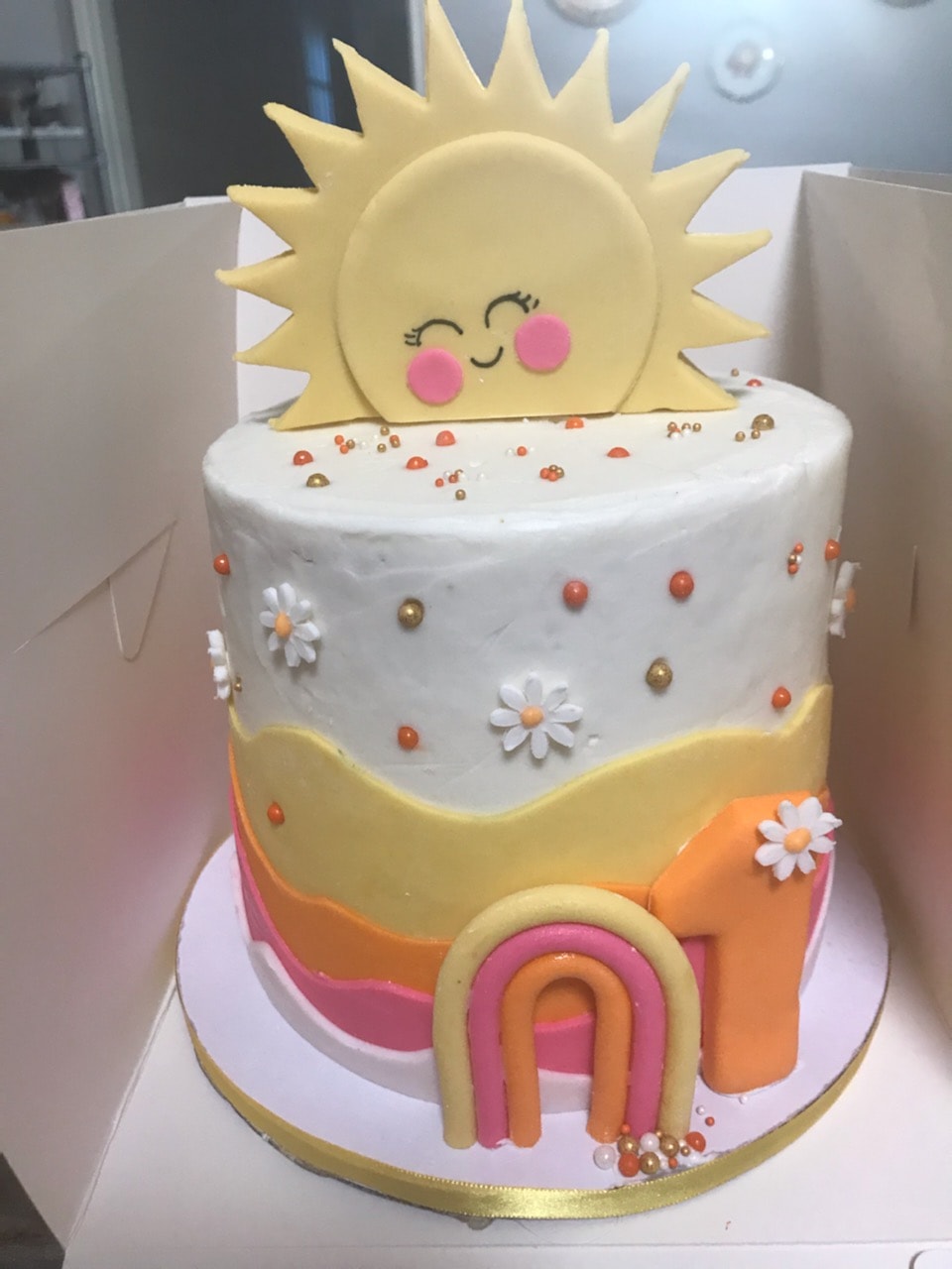 Sunshine first birthday tiered cake with daisies