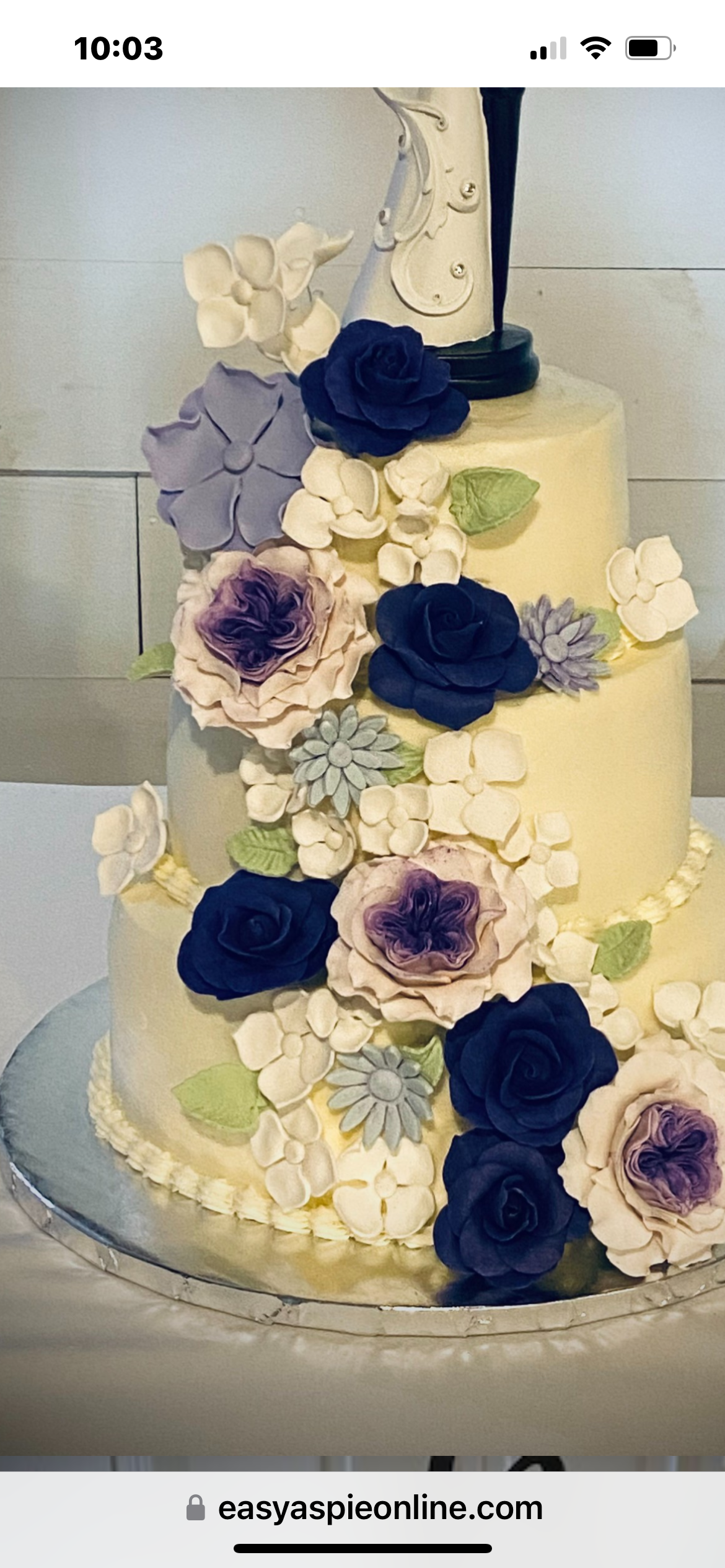 Winnie the Pooh cake with white floral topper and bumblebee accents