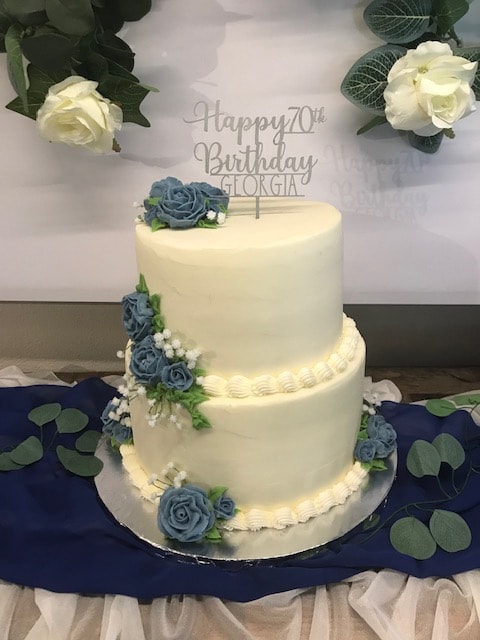 Two-tier Happy 70th Birthday cake with blue roses