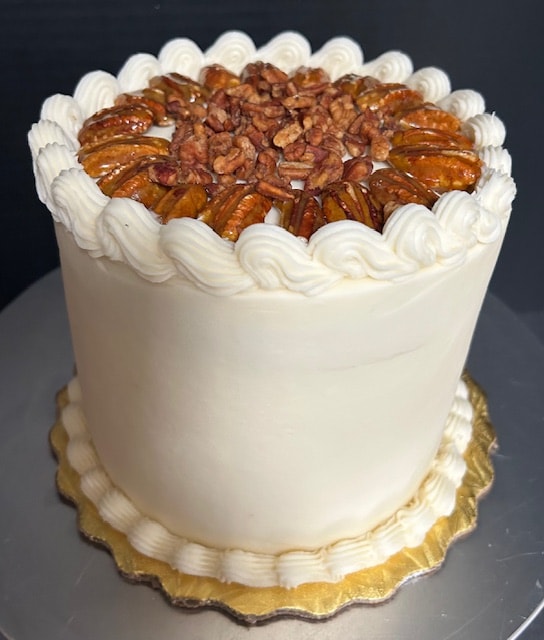 Butter pecan layer cake with white frosting and pecan topping