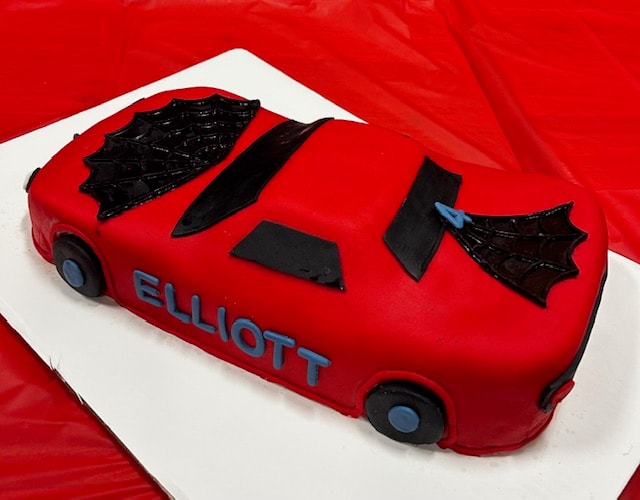 Elliott red car shaped birthday cake with spiderweb details