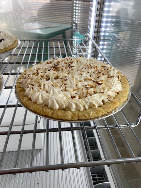 Coconut cream pie with toasted coconut and whipped cream rosettes
