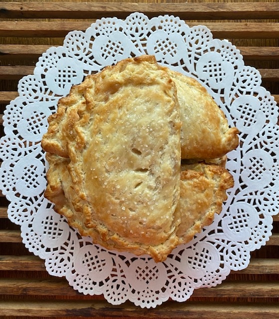 Golden hand pies stacked on decorative doily